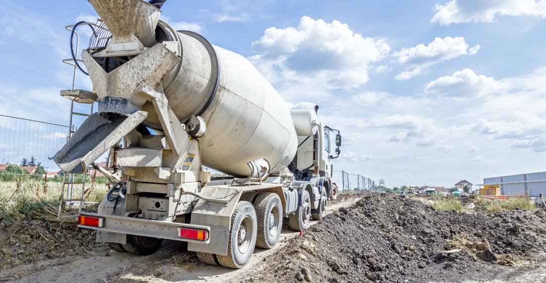 Cement truck driving through construction site.