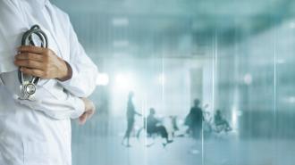 A doctor holding a stethoscope with the silhouettes of patients in the background.